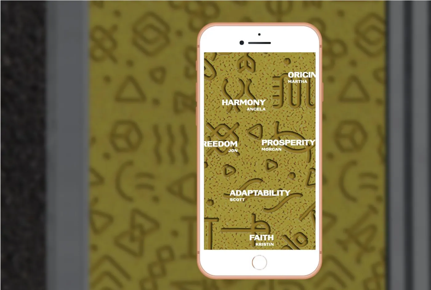 A phone held over the pattern decodes glyphs into words like Harmony, Prosperity and Faith